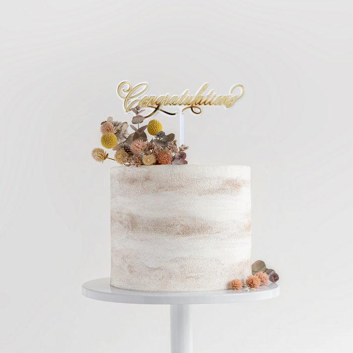 “Congratulations” Cursive Pre-Made Cake Topper in a cake